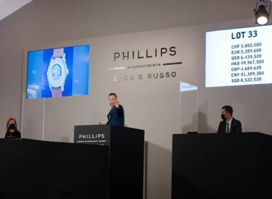 Auctioneer Aurel Bacs selling the Patek Philippe Ref. 2523 yellow gold two-crown Worldtime “The Silk Road” for CHF 7 million